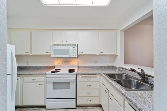 kitchen with white appliances, white cabinets, a sink, and light countertops