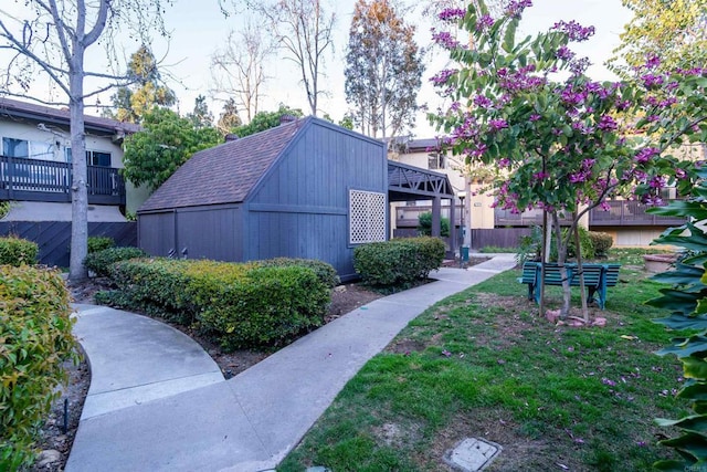 view of home's community featuring fence and an outdoor structure