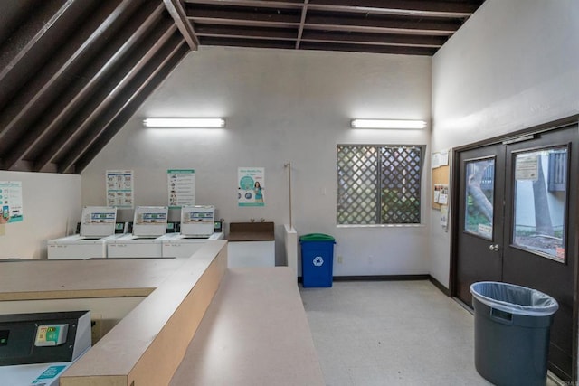 interior space featuring lofted ceiling with beams, independent washer and dryer, baseboards, and tile patterned floors