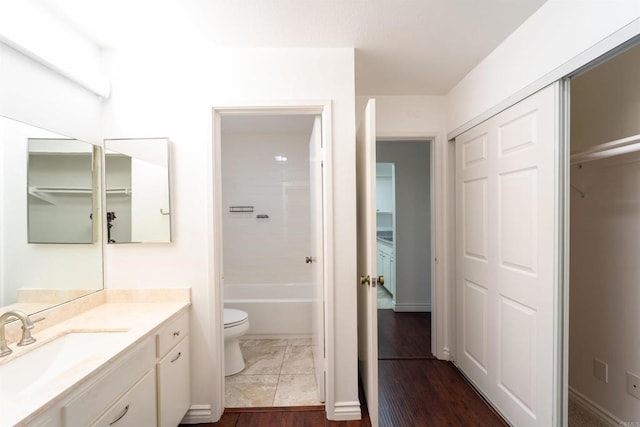 full bathroom with a washtub, wood finished floors, vanity, and toilet