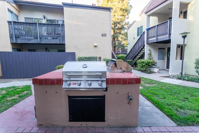 view of patio / terrace featuring a grill, fence, stairway, and area for grilling