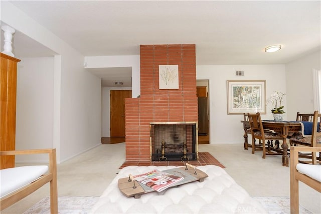 carpeted living room with a fireplace and visible vents