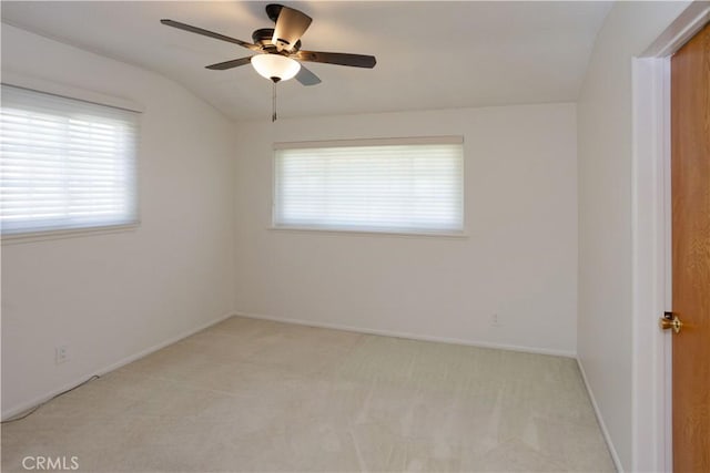 spare room with light carpet, baseboards, a ceiling fan, and lofted ceiling