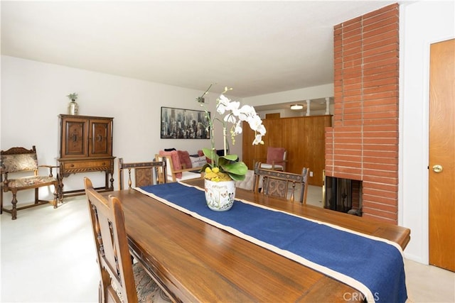 dining area featuring a brick fireplace and light colored carpet