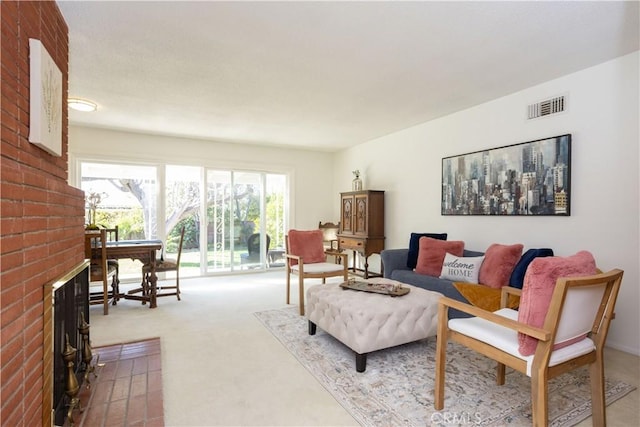 living area featuring visible vents, a fireplace, and carpet flooring