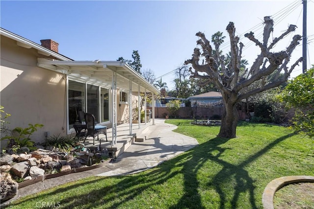 view of yard featuring fence and a patio