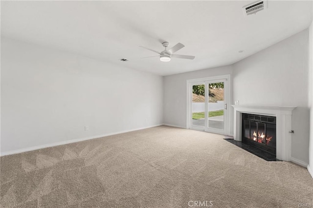 unfurnished living room with a fireplace with flush hearth, visible vents, carpet floors, and a ceiling fan