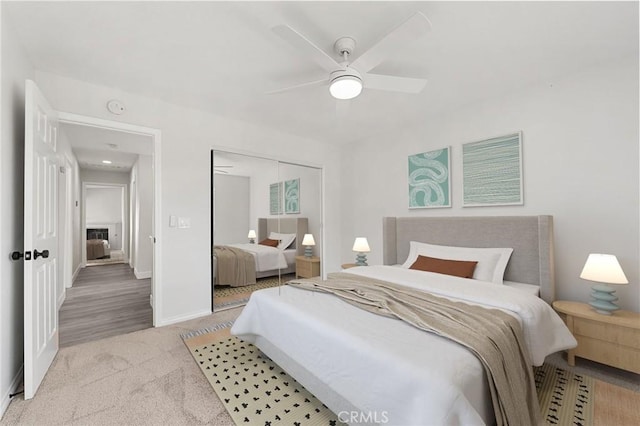 carpeted bedroom featuring a closet, ceiling fan, and baseboards