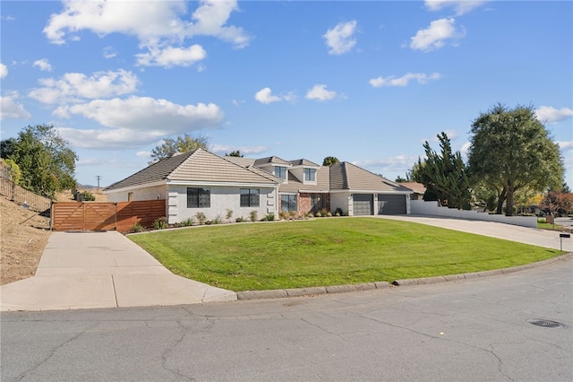 view of front of home with an attached garage, a tile roof, fence, concrete driveway, and a front lawn