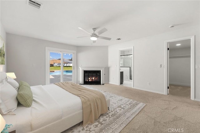 carpeted bedroom with access to exterior, a fireplace with flush hearth, visible vents, and baseboards