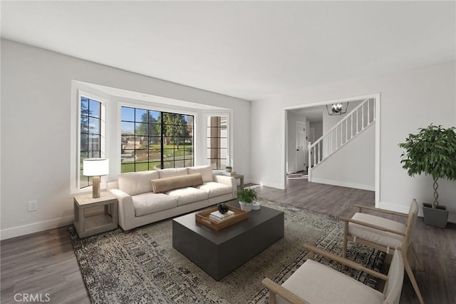 living room with stairs, baseboards, a chandelier, and wood finished floors