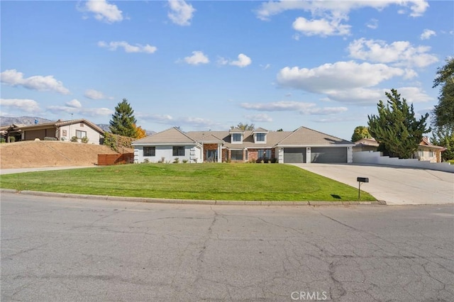 view of front of home featuring a garage, concrete driveway, a front yard, and fence