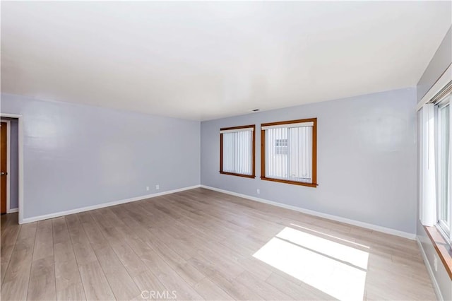 unfurnished room with light wood-style floors and baseboards