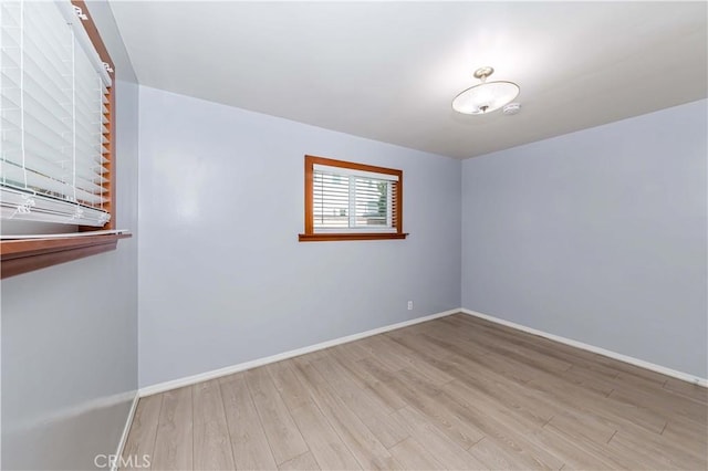 unfurnished room featuring baseboards and wood finished floors