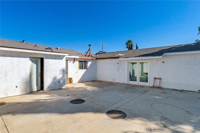 rear view of house featuring a patio area, french doors, and stucco siding