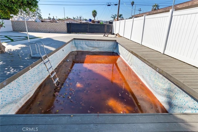 view of pool with a fenced backyard and a wooden deck