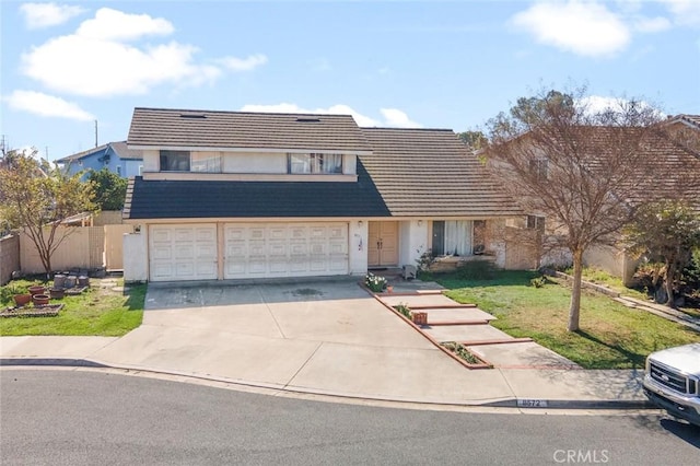 view of front of home featuring a garage, driveway, a front yard, and fence