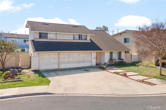 view of front of house with driveway, fence, and stucco siding