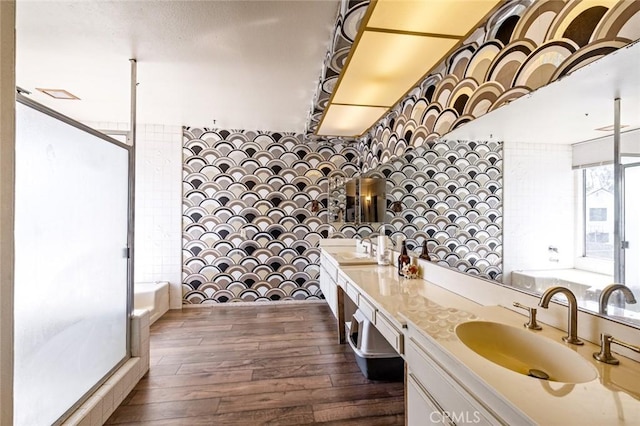 full bath featuring a shower, a sink, a bathing tub, and wood finished floors