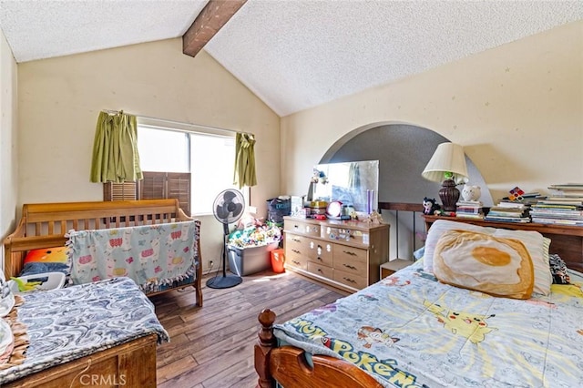 bedroom with lofted ceiling with beams, hardwood / wood-style floors, and a textured ceiling