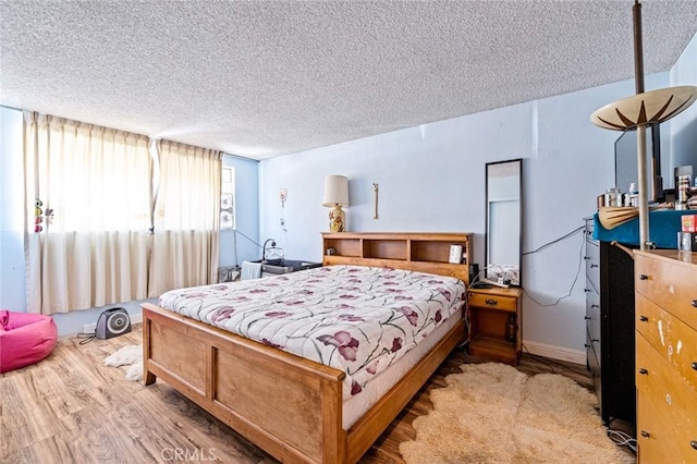 bedroom featuring a textured ceiling and light wood-type flooring