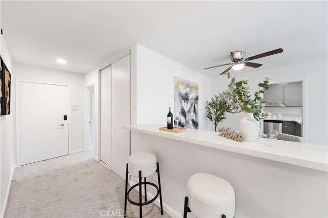 bar area with ceiling fan, dishwasher, light colored carpet, baseboards, and recessed lighting