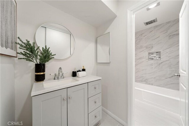 bathroom featuring vanity, baseboards, and  shower combination