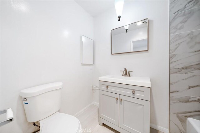 full bathroom featuring toilet, vanity, and baseboards