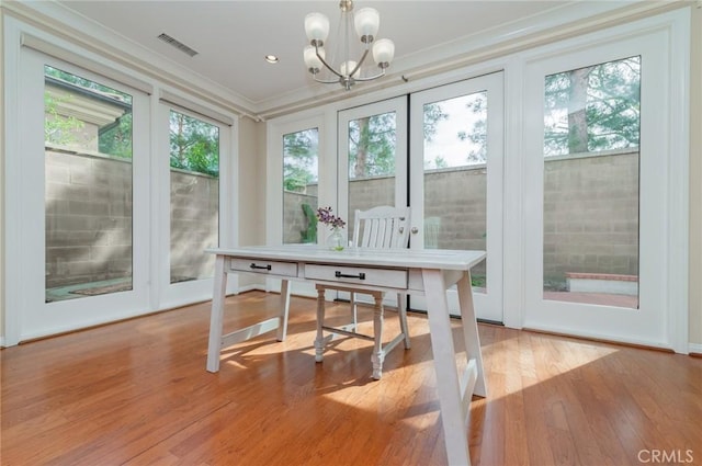 sunroom / solarium featuring visible vents, plenty of natural light, and a notable chandelier