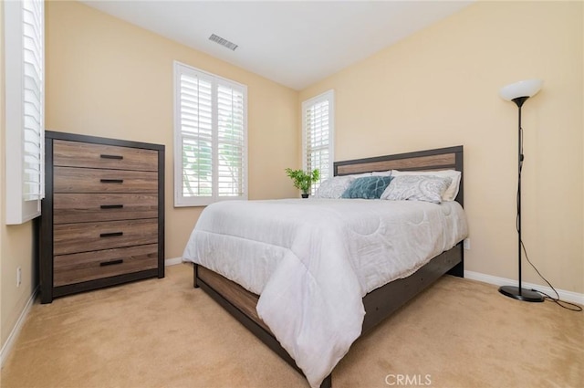 carpeted bedroom with baseboards and visible vents