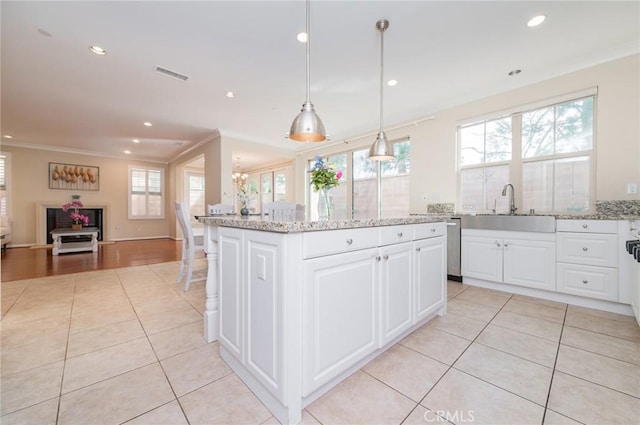 kitchen featuring visible vents, open floor plan, a sink, and light tile patterned flooring