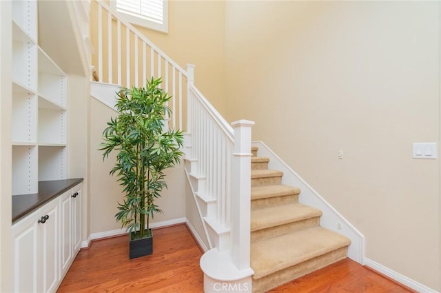 stairway with baseboards and wood finished floors