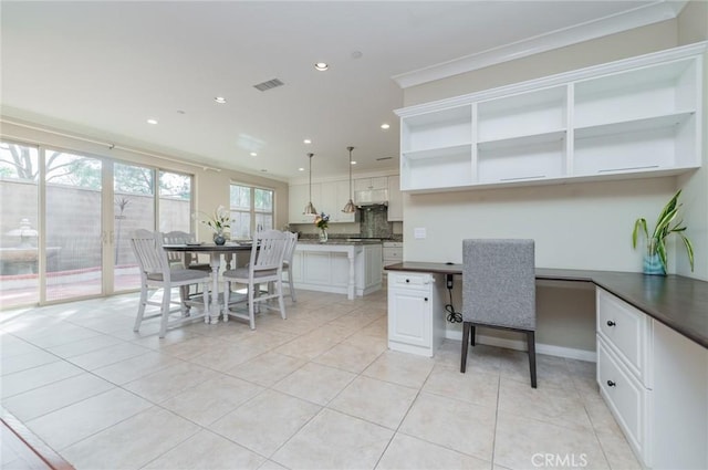 dining area with light tile patterned flooring, recessed lighting, visible vents, built in desk, and crown molding