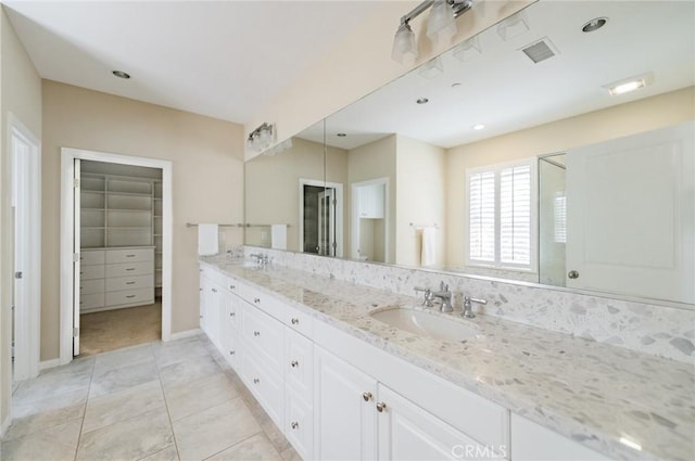 full bath featuring double vanity, visible vents, a sink, and a shower with shower door