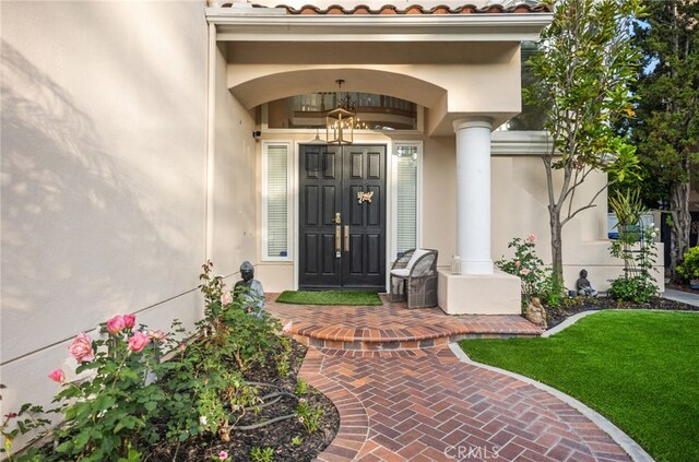 entrance to property featuring a tiled roof and stucco siding