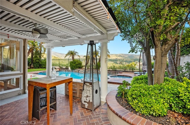 view of patio / terrace with a mountain view, an in ground hot tub, a fenced backyard, and a fenced in pool