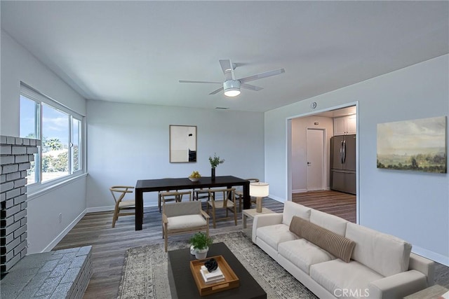 living room with ceiling fan, dark wood-style flooring, and baseboards