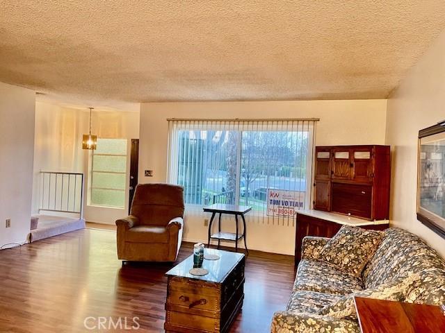 living room with a textured ceiling and dark wood finished floors