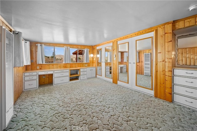 sunroom featuring french doors and built in desk