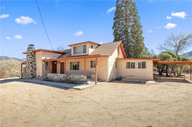 31251 Aliso Canyon Rd, Acton, CA 93550 - back of property with a chimney, stucco siding, driveway, a carport, and a porch