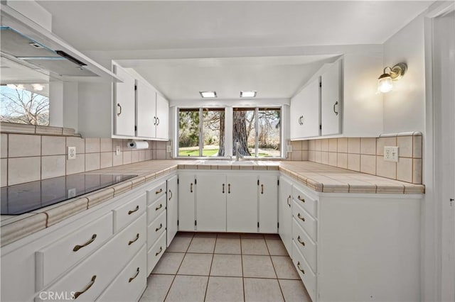 31251 Aliso Canyon Rd, Acton, CA 93550 - kitchen with white cabinets, wall chimney exhaust hood, decorative backsplash, tile countertops, and light tile patterned floors