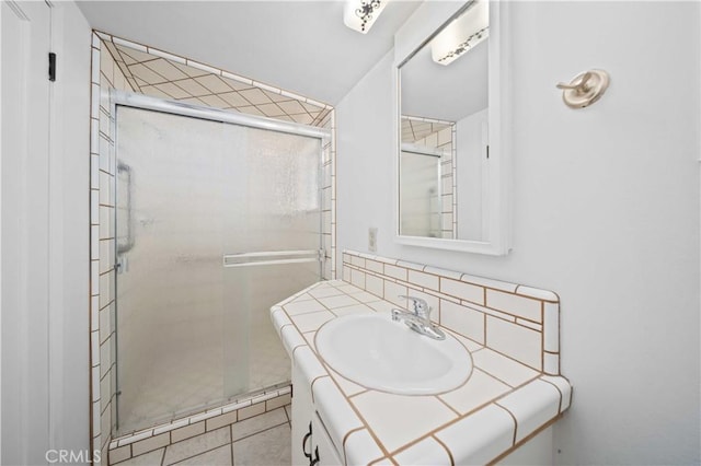 bathroom with tile patterned floors, a shower stall, and vanity