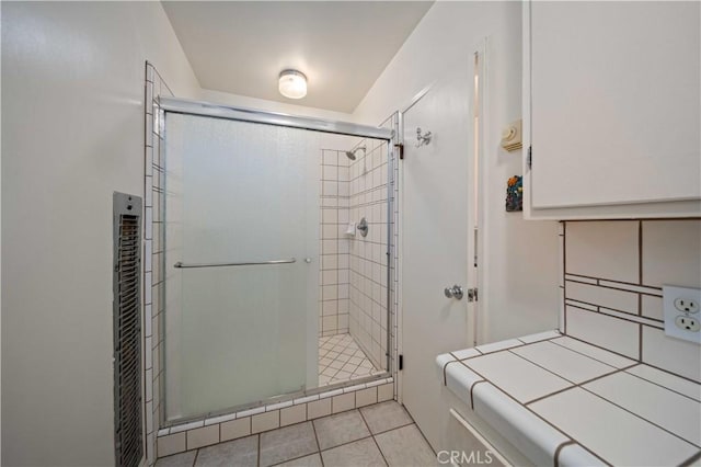 full bathroom featuring tile patterned flooring and a shower stall