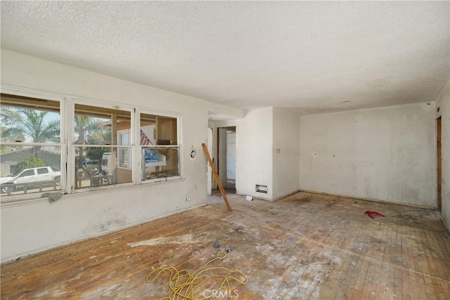 unfurnished room with a textured ceiling