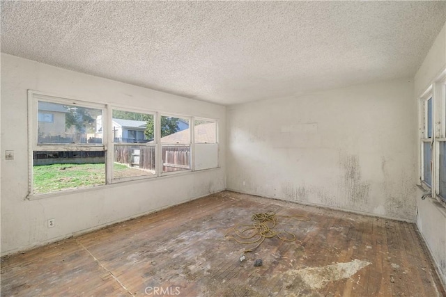 unfurnished room with a textured ceiling