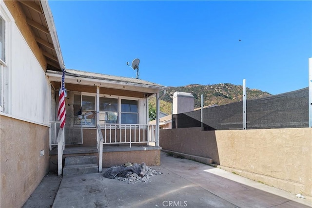 exterior space featuring a porch, fence, and a mountain view