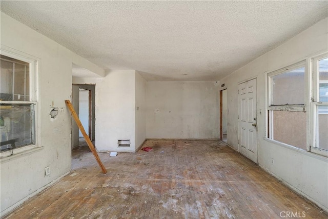 unfurnished room with a textured ceiling