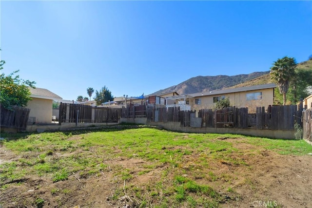 view of yard featuring fence and a mountain view