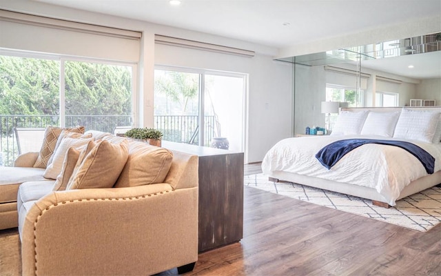 bedroom featuring access to exterior, recessed lighting, and wood finished floors