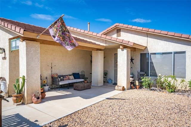 exterior space with a patio area, outdoor lounge area, and stucco siding